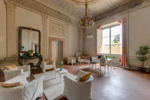 un ampio soggiorno con sedie e specchio di Residenza d'Epoca Sant Egidio a Firenze
