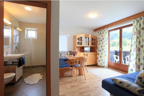 two views of a living room and a bathroom at Haus Katharina in Westendorf