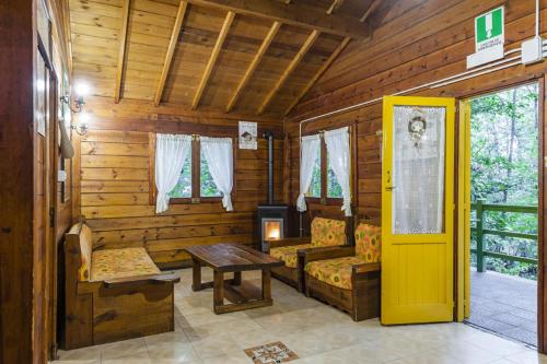 a log cabin with a table and a yellow door at CHALET ETNA MILO in Milo