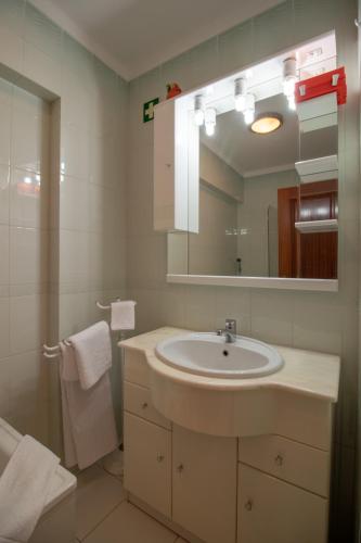 a bathroom with a sink and a mirror at Quarteira Beach in Quarteira
