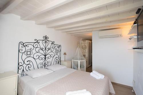 1 dormitorio con cama blanca y cabecero blanco y negro en Beautiful Apartment With Amazing View, In Mykonos Old Town, en Mykonos ciudad