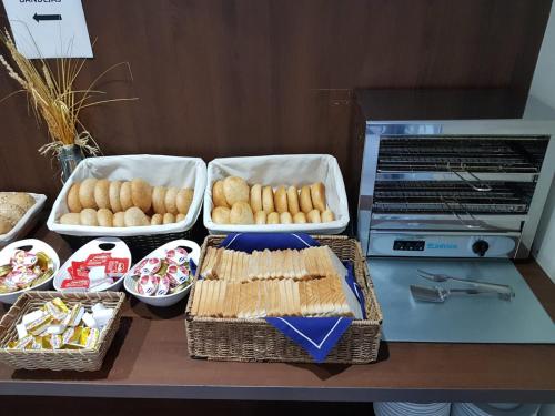 a table with three trays of food on a counter at Hotel Olympia Universidades in Valencia