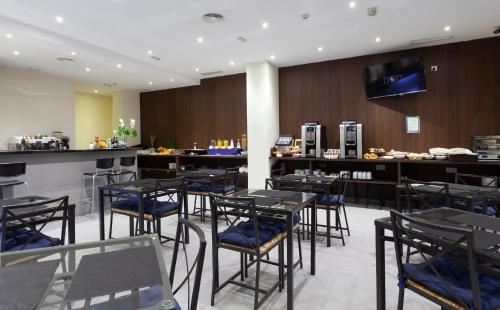 a restaurant with tables and chairs and a bar at Hotel Olympia Universidades in Valencia