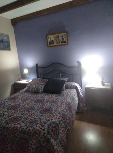 a bedroom with a bed and two night stands with lamps at Casa Rural El Arroyo in Sotoserrano
