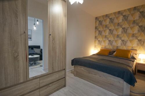 a bedroom with a bed and a mirror at Apartament z widokiem na morze in Dziwnów