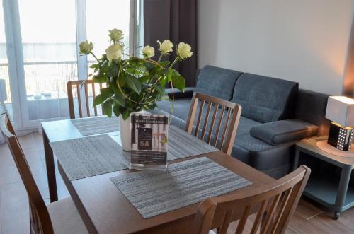 a dining room table with a vase of flowers on it at Villa Corleone in Kąty Wrocławskie