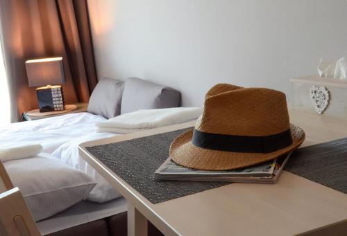 a hat sitting on a table next to a bed at Villa Corleone in Kąty Wrocławskie