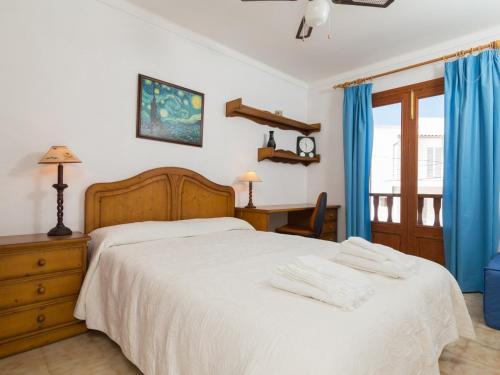 1 dormitorio con cama blanca y cortinas azules en Villa joy, en Playa de Muro