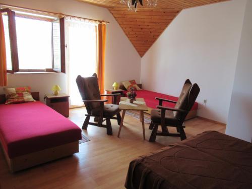 una camera con letto, tavolo e sedie di 2+2 fős apartman Badacsonytomaj központjában a Badacsonytomaj