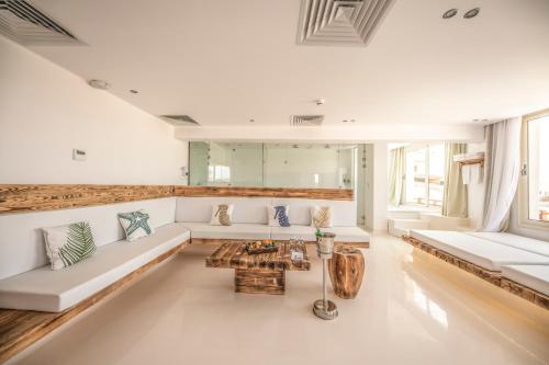 a living room with white couches and a table at Meraki Resort - Adults Only in Hurghada