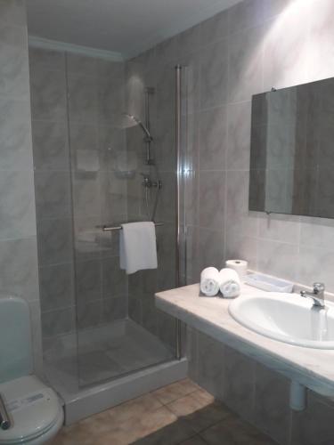 
a bathroom with a shower, sink, and toilet at Hotel Avenida in Benicàssim
