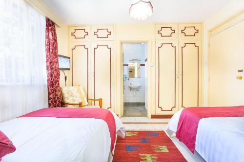 a bedroom with two beds and a bathroom at Methodist Resort in Nairobi