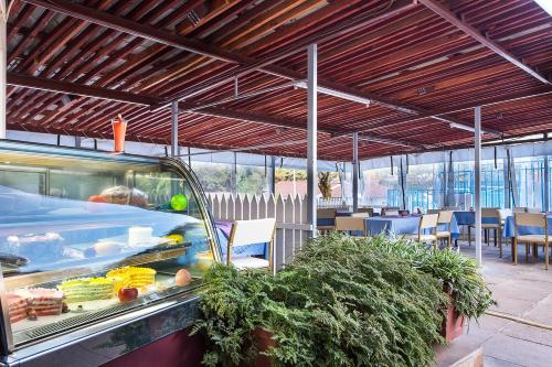 a restaurant with a food counter and tables and chairs at Methodist Resort in Nairobi