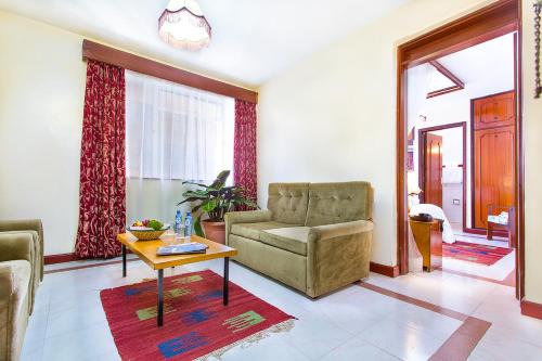 a living room with a couch and a chair and a table at Methodist Resort in Nairobi