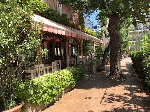 a restaurant with tables and chairs and a tree at Oleander House and Tennis Club in Sunny Beach