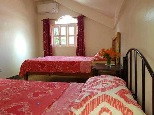 a bedroom with two beds and a window at OMG Guesthouse Room for 3 pax in Licup
