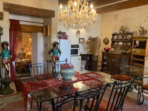 a kitchen with a table and chairs and a chandelier at Knights In Malta in Naxxar