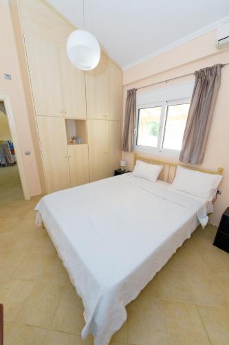 a large white bed in a room with a window at Analipsi House Afrodite in Kástro Tornéze