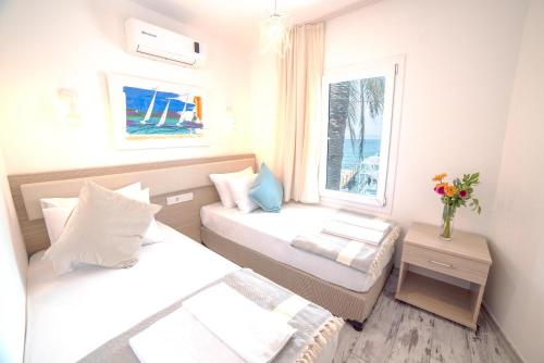 Una pequeña habitación con dos camas y una ventana. en Madda Hotel, en Golturkbuku