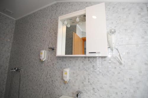 ein Badezimmer mit einem weißen Schrank und einem Spiegel in der Unterkunft Ninkovic in Trebinje