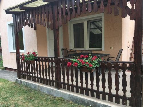 een houten hek met bloemen op een huis bij Balatonfenyves - Munkácsy u. 6. in Balatonfenyves