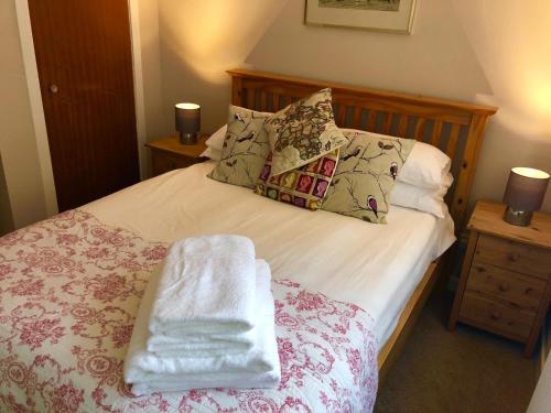 a bedroom with a bed with towels on it at But & Ben in Balloch in Balloch