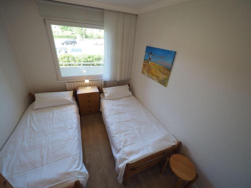 ein kleines Zimmer mit 2 Betten und einem Fenster in der Unterkunft Appartement 89 in Westerland