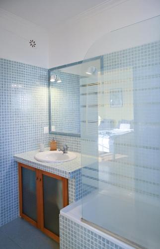 a bathroom with a sink and a mirror at Coworksurf - Villa dos Irmãos in Ericeira