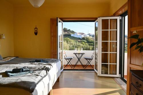 a bedroom with a bed and a sliding glass door at Coworksurf - Villa dos Irmãos in Ericeira