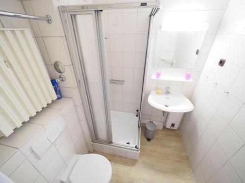 ein Bad mit einer Dusche, einem WC und einem Waschbecken in der Unterkunft Appartement 89 in Westerland