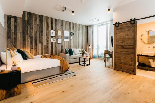 1 dormitorio con 1 cama y pared de madera en Ski&Sun Apartamenty, en Świeradów-Zdrój