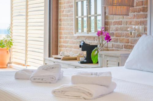 a white bed with two towels on top of it at Agorastos Hotel in Koinyra