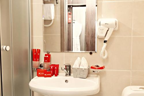 uma casa de banho com um lavatório e um espelho em AZIMUT Hotel Penza em Penza