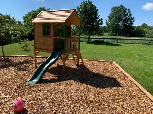 a small playground with a slide in a yard at Appartementanlage Lancken-Granitz in Lancken-Granitz