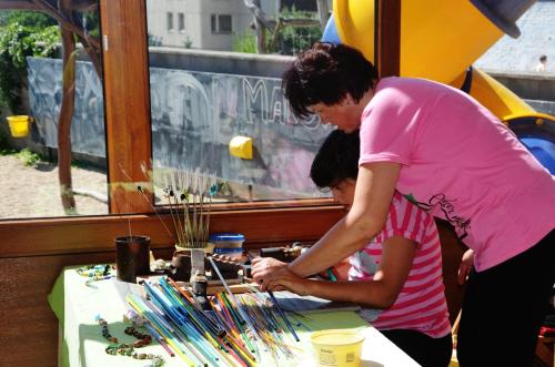 a woman and a girl looking at a table with beads at Penzion Bejby Turnov in Turnov