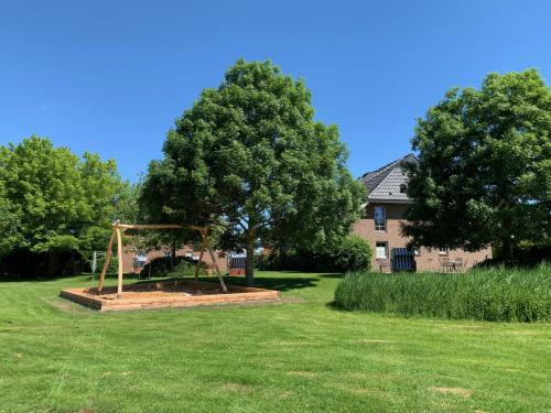 a playground in a yard with a tree at Appartementanlage Lancken-Granitz in Lancken-Granitz