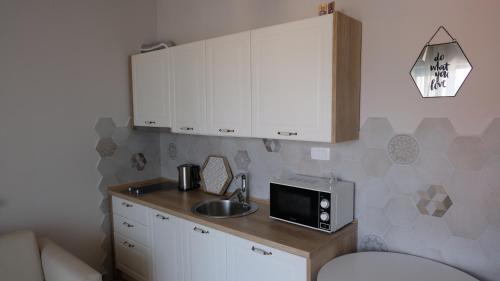 a small kitchen with a sink and a microwave at Kazanegra Exclusive Apartments in Sveti Stefan