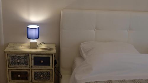 a bedroom with a bed and a lamp on a night stand at Kazanegra Exclusive Apartments in Sveti Stefan