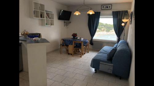 a living room with a blue couch and a table at Studio « Les pieds dans l’eau » in Martigues