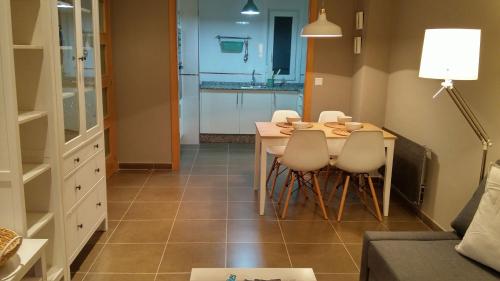 uma sala de jantar com mesa e cadeiras e uma cozinha em Apartamento con piscina en Foz em Foz