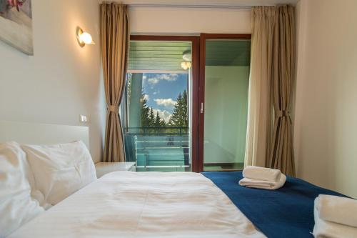 - une chambre avec un grand lit et une fenêtre dans l'établissement Family Apartment in Silver Mountain Resort, à Poiana Brasov