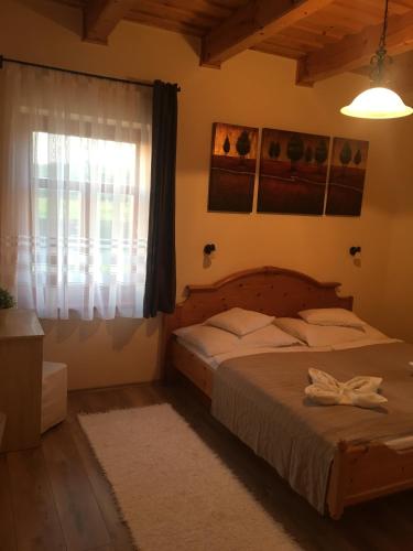 a bedroom with a bed and a window at Termálvölgye Vendégház in Demjén