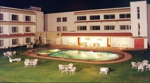 una piscina en el patio de un edificio por la noche en Hotel Express Residency-Jamnagar en Sika