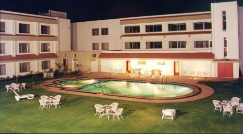 una piscina en el patio de un edificio por la noche en Hotel Express Residency-Jamnagar, en Sika
