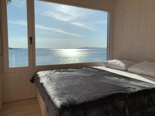 - une chambre avec une grande fenêtre donnant sur l'océan dans l'établissement Beachvilla Nawin / Haus 23, à Pakoštane