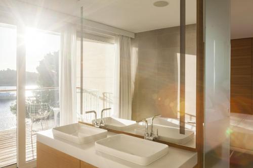 a bathroom with two sinks and a large window at D-Resort Šibenik in Šibenik
