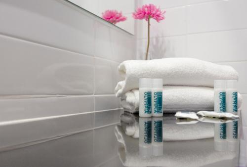 a bathroom with towels on a counter and a mirror at Hotel Olympia Universidades in Valencia