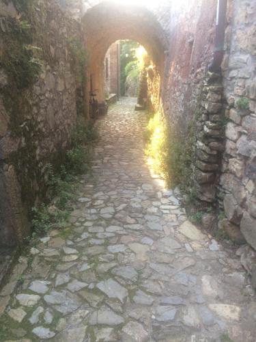 a stone alley with an arch in a stone wall at Medieval Village B&B in Ne