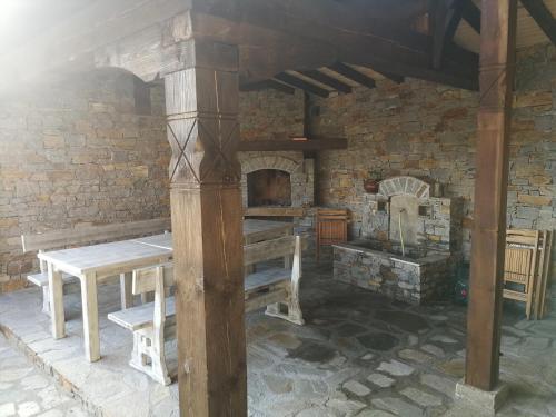 a stone room with a table and a fireplace at Слънчевата къща in Kovachevitsa