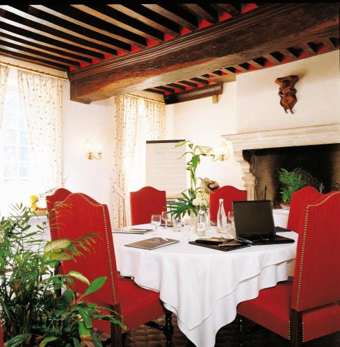 a dining room with a table with a laptop on it at Château de Fleurville & Spa in Fleurville